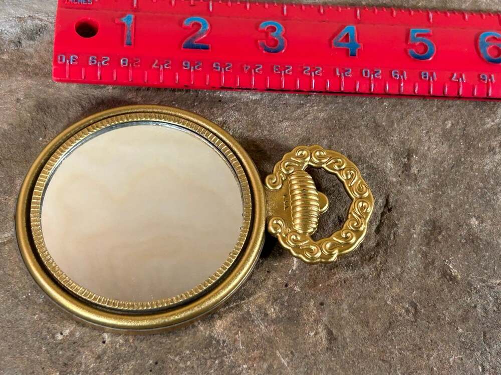 VTG ornate gold tone hand mirror with Roman clock on back made in USA